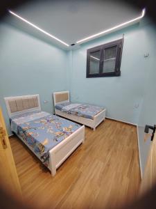 two beds in a room with a window at Villa zahra 7 in Kêf Bisnês