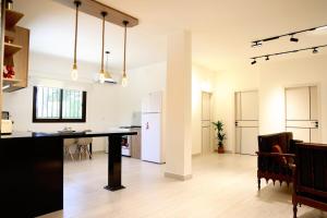 an open kitchen and living room with a table and refrigerator at Casa de Simoncis in Batroûn