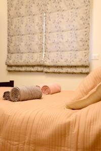 a bed with two pillows on it with a window at Casa de Simoncis in Batroûn
