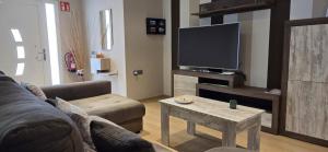 a living room with a couch and a tv at Lo de Joel in Els Muntells