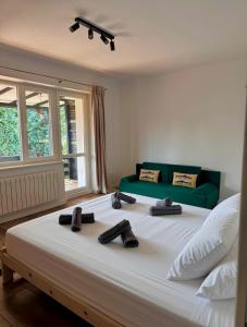 a large white bed with two pairs of shoes on it at Przystań Jeziorna in Pasym