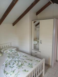 a white bedroom with a bed and a mirror at Source de vie - Campagne in Capesterre-Belle-Eau