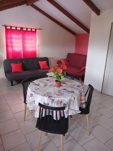 a living room with a table with chairs and a couch at Source de vie - Campagne in Capesterre-Belle-Eau