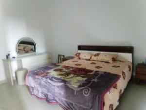 a bedroom with a bed with a blanket and pillows at Flora House in Maputo