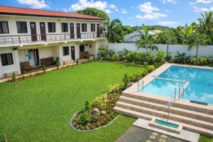 a backyard with a swimming pool and a house at DMS Apartelle in Los Baños