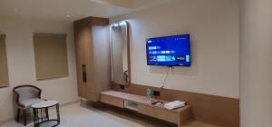 a hospital room with a tv on the wall at Hotel Centrum in Surendranagar