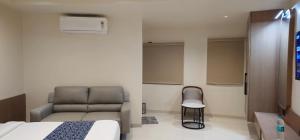 a bedroom with a bed and a couch and a chair at Hotel Centrum in Surendranagar +7 photos