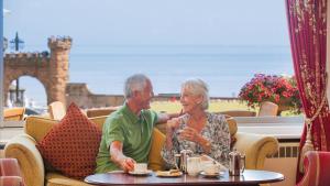 a man and a woman sitting at a table at The Belmont Hotel in Sidmouth