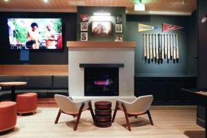 a living room with a fireplace with chairs and a tv at SoMa House in San Francisco