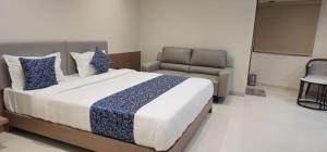 a bedroom with a large bed and a couch at Hotel Centrum in Surendranagar