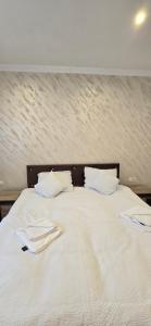 a bed with white sheets and pillows on it at Casa Chișcău - Valea Urșilor in Chişcău