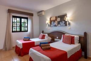 a hotel room with two beds with red and white at Ona Las Casitas in Playa Blanca +49 photos