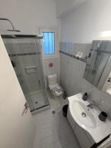 a bathroom with a shower and a sink and a toilet at Sidari Centre Apartments in Sidari +12 photos
