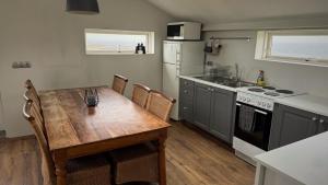 a kitchen with a wooden table and a kitchen with a stove at Snaefell Apartments in Hellissandur
