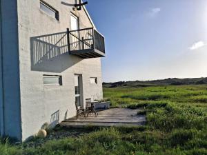 a building with a balcony and a table and a chair at Snaefell Apartments in Hellissandur