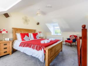 a bedroom with a large bed with red and white pillows at 1 Bed in Conwy oc-79357 in Llangelynin