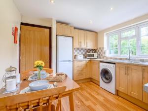 a kitchen with wooden cabinets and a white refrigerator at 1 Bed in Conwy oc-79357 in Llangelynin