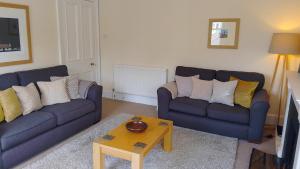 a living room with two couches and a coffee table at Turret View - spacious central location in Peebles