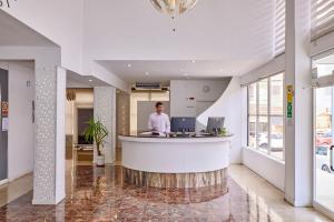 a man standing at a counter in a lobby at Welikehotel Fenix in El Arenal +72 photos