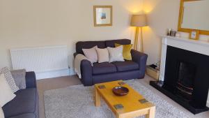 a living room with a couch and a fireplace at Turret View - spacious central location in Peebles