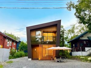 a house with a wooden door and an umbrella at KOMU Hakuba in Hakuba