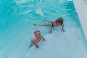 a woman and a child swimming in a swimming pool at ZAN Uhuru Beach in Jambiani