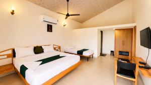 a bedroom with a bed and a desk and a tv at Unity Sunrise Resort Statue of Unity Ekta Nagar in Kevadia