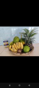 a basket of bananas and other fruits on a table at Kwetu nungwi in Kinyasini +10 photos