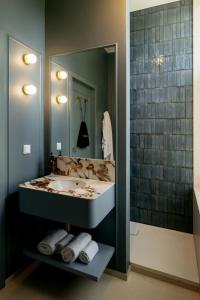 a bathroom with a sink and a large mirror at Hotel Kasteel Doenrade in Doenrade