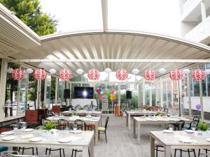 ein Restaurant mit weißen Tischen und rot-weißer Dekoration in der Unterkunft Mercure Galati Centrum in Galaţi