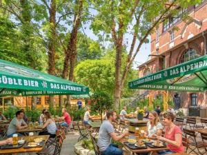 a group of people sitting at tables at an outdoor restaurant at Hotel Altes Sudhaus in Kassel +5 photos