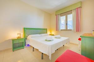 a bedroom with a large white bed and a window at Apartamento Larimar - PlusHolidays in Ifach +41 photos