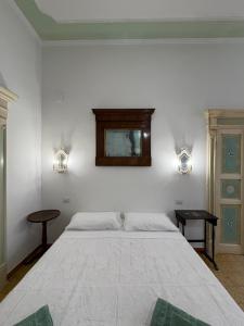 a bedroom with a large bed and a mirror on the wall at Atelier Peretti in Alghero