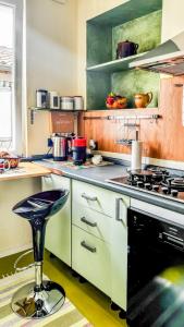 a kitchen with a stove and a stool at Moon's House Oropa in Biella