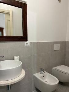 a bathroom with a sink and a toilet and a mirror at Atelier Peretti in Alghero