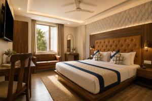 a bedroom with a large bed and a desk at Hotel Smart Premier -Delhi Airport in Behror