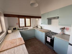 a kitchen with blue cabinets and a stove top oven at Villa Ann Lanzarote in Nazaret