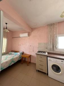 a small room with a bed and a washing machine at Yalçın Pansiyon in Silifke
