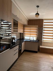 a kitchen with white cabinets and a black counter top at Apparemment La Perla in Banzart +6 photos