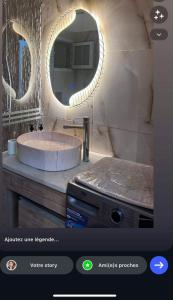 a bathroom with a round sink and a mirror at Apparemment La Perla in Banzart
