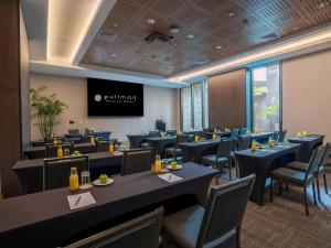 a dining room with tables and chairs and a screen at Pullman Lima Miraflores in Lima