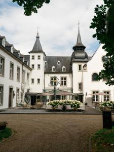 a large white building with two turrets at Hotel Kasteel Doenrade in Doenrade