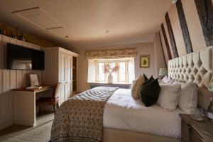 a bedroom with a bed and a desk and a window at The Porch House in Stow on the Wold