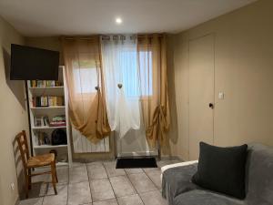 a living room with a couch and a window at T1 Meublé in Saint-Chamond
