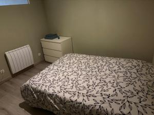 a bedroom with a bed and a dresser at T1 Meublé in Saint-Chamond
