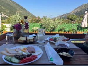 ein Tisch mit Tellern voller Essen auf einem Tisch mit Aussicht in der Unterkunft Lean chalet Sea&Mountain view in Dukat + 11 Fotos