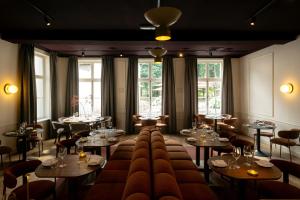 a restaurant with tables and chairs and windows at Hotel Kasteel Doenrade in Doenrade +19 photos
