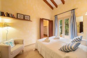 a bedroom with a bed and a chair and a window at Villa Calvario by Sealand Villas in Pollença +26 photos
