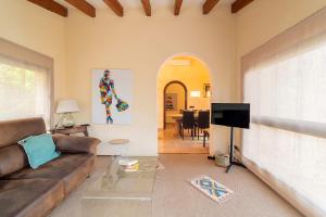 a living room with a couch and a television at Villa Calvario by Sealand Villas in Pollença