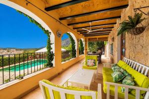 an outdoor patio with a couch and chairs and a pool at Villa Calvario by Sealand Villas in Pollença